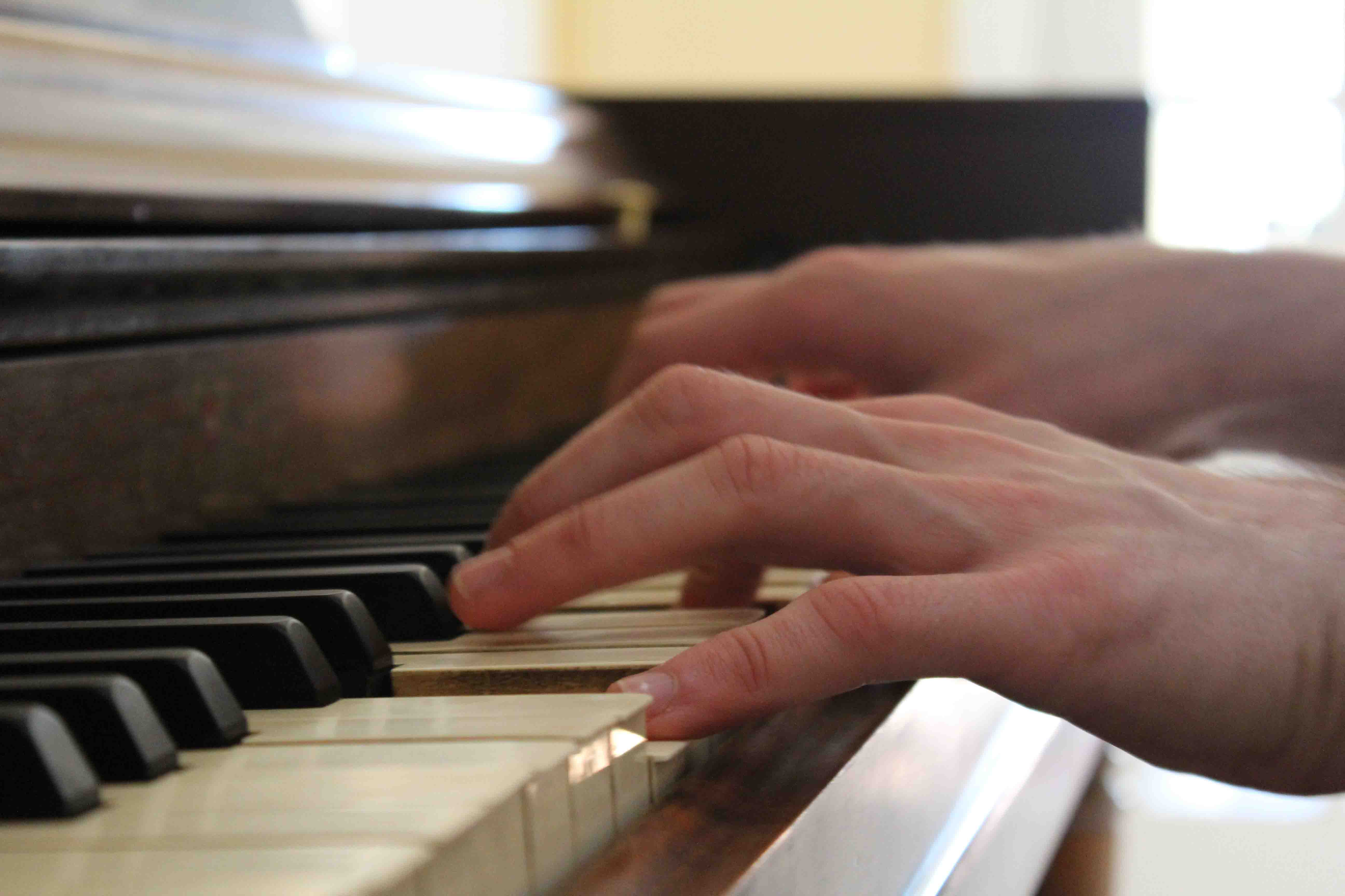 original photography of a close up of hands playing the piano.