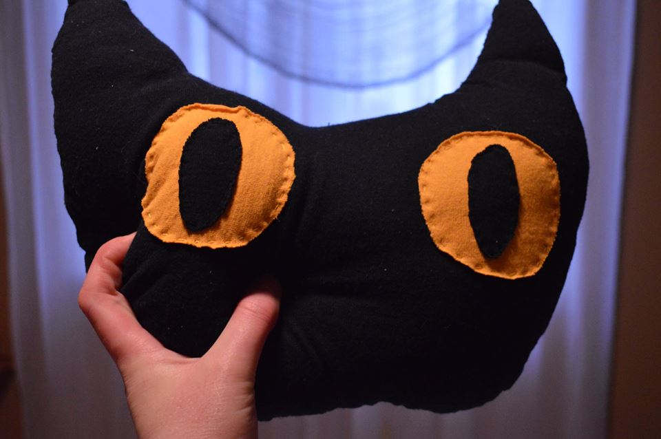 a pillow shaped like a cat face