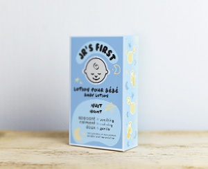 Baby lotion packaging displayed on a wooden platform