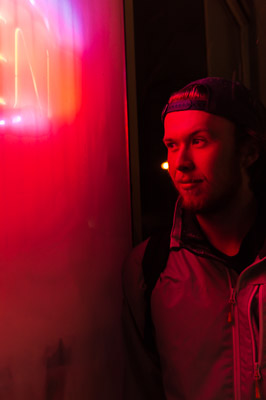 A man beside a neon open sign