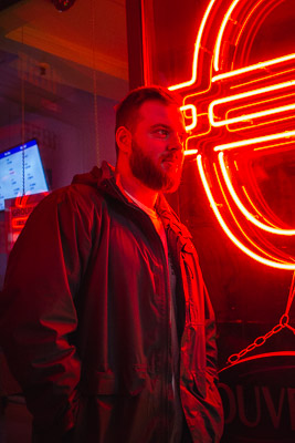 A man beside a neon sign