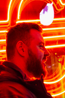 A man beside a neon sign