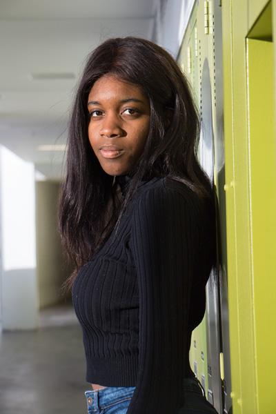 This is a head shot of a girl against green lockers