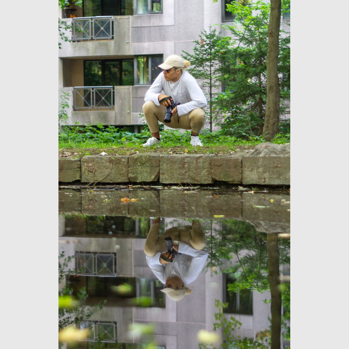 Tim Claude reflected in water, ready to snap some pics