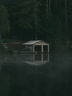 beige boathouse nestled in monring fog